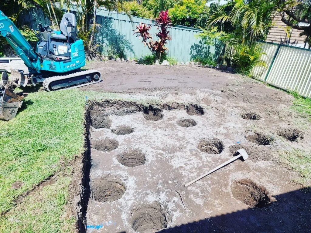 Backyard levelled with post holes augered for a new deck